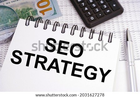 Business and finance concept. On the table there is money, a calculator and a notebook with the inscription - SEO STRATEGY
