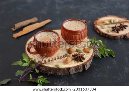 Top view of Indian herbal Masala Chai or traditional beverage tea with milk and spices Kerala India. Two cups of organic ayurvedic or herbal drink India, good in winter for immunity boosting. Royalty-Free Stock Photo #2031637334