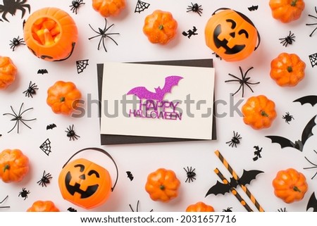 Top view photo of black envelope glitter purple bat and inscription happy halloween on white card pumpkin baskets candy corn straws spiders web witch and bats silhouettes on isolated white background