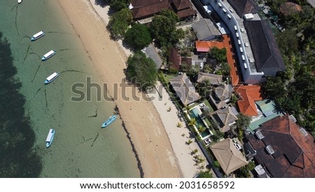 Aerial shot landscape beachfront property with boats at the ocean 