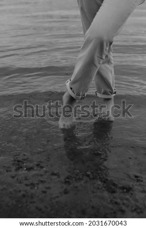 walking on the sea, blurry and fuzzy black and white film photography, body parts and water