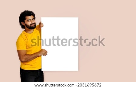 Young handsome Indian man holding empty sign board and serious look, Looking at camera
 Royalty-Free Stock Photo #2031695672