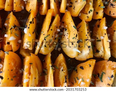 Fresh yellow tomato  in garlic,seasoned with dried basil with sunflower oil and rosemary. Dried tomatoes.Summer mood.Photos for food magazines,posters,picture on the menu for cafes and restaurants.