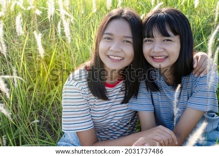Happy two young girl at meadow beautiful nature background.