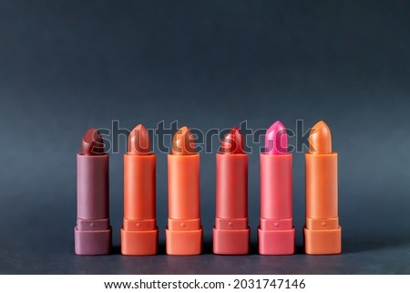 Set of fashion lipsticks palette in red, brown and pink colors, studio photo on black background. Beautiful make-up or cosmetic sale concept