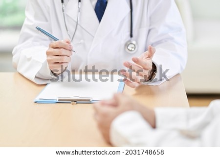 Hands of a male doctor explaining symptoms to the patient Royalty-Free Stock Photo #2031748658