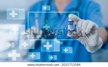Double exposure of healthcare And Medicine concept. Doctor holding 
a vaccine or medicine against covid-19 and modern virtual screen interface icon.