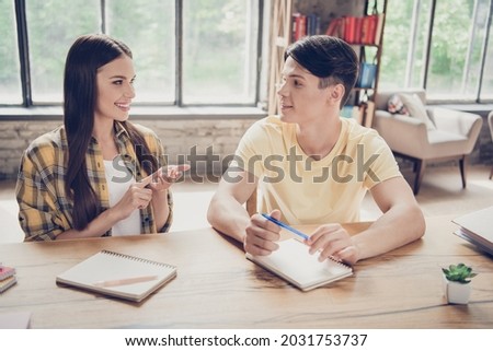Photo of young smiling two people students talking writing in notebook library girl counting explain math indoors Royalty-Free Stock Photo #2031753737