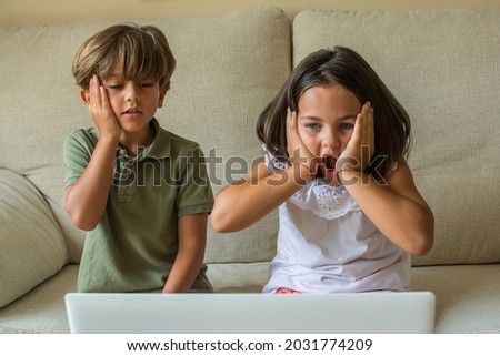 Children At home.
Stock Photo Of A Boy And A Girl At Home Watching A Movie Or Series On The Computer. They Have Fun And Have Fun Skills.