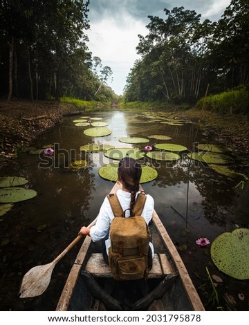 
Woman explorer travels an Amazon river in a canoe Royalty-Free Stock Photo #2031795878