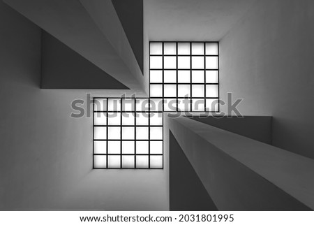 Bright quadratic roof windows with vanishing point and symmetry. Abstract black and white grey scale perspective. Inside a modern room from floor to ceiling. Royalty-Free Stock Photo #2031801995