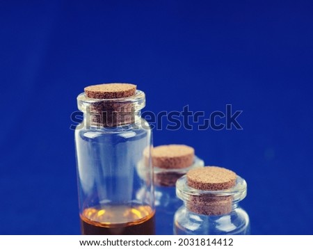 Several medical bottles, test tubes with a cork on a blue background.