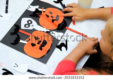 Child making pumpkins for the holiday of hallow