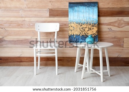 Chair with table near wooden wall in room
