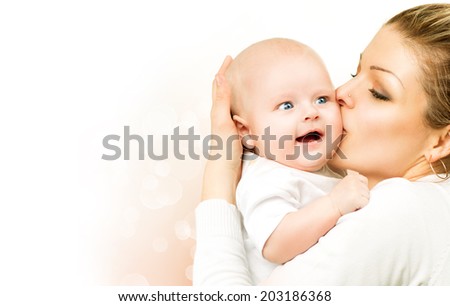 Mother and Baby kissing and hugging. Beautiful mom with her child portrait. Happy Family isolated on a white background. Parenthood, motherhood concept 