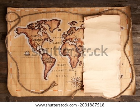 Vintage pirate map and blank sheet of papyrus with place for text on a round wooden table