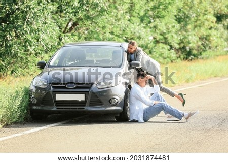 Young couple near broken car on road