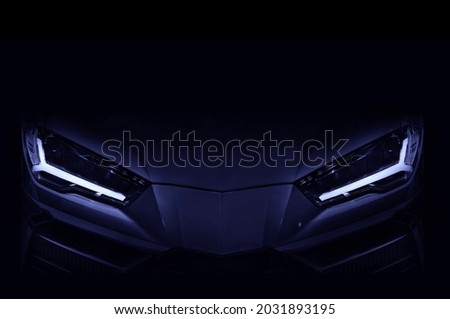 Silhouette of black sports car with LED headlights on black background, copy space	 Royalty-Free Stock Photo #2031893195