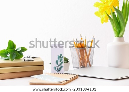 Stationery and flowers on table in office