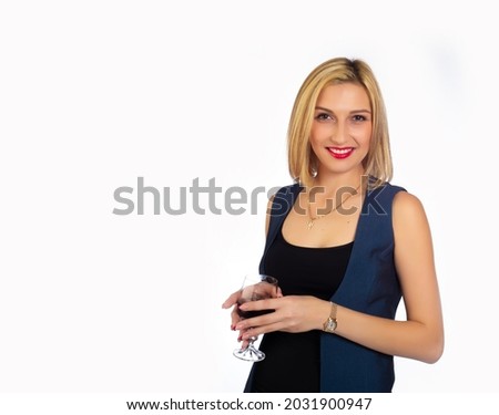 Studio photo of a model, blonde in a blue pantsuit, with a glass of wine, isolated on white background