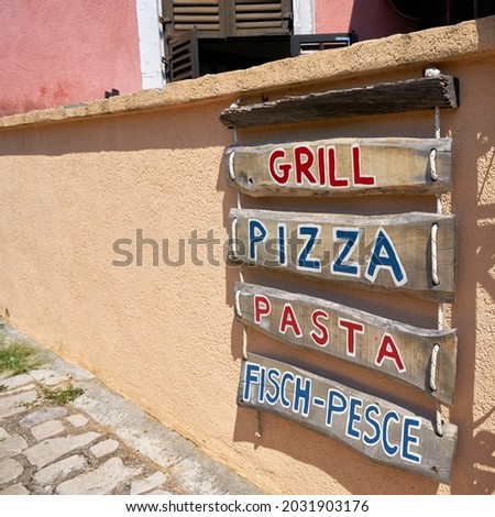  Advertisement for a typical restaurant in an alley in the old town of Krk in Croatia                              