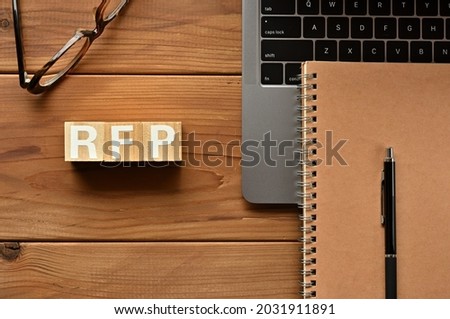 On the table there is a word cube lined RFP with laptop computers and glasses. It is an abbreviation for the word Request For Information. Royalty-Free Stock Photo #2031911891