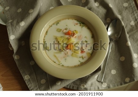 Hot homemade Finnish cream soup with vegetables and trout, served in a simple plate, simple cuisine Royalty-Free Stock Photo #2031911900