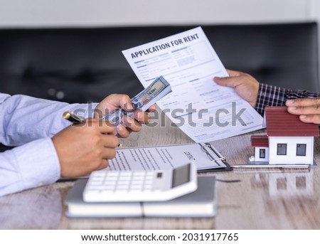 Sale purchase contract to buy a house, Real estate agent are presenting home loan after signing contract to buy house with approved property application form,Homebuyer are sign contract