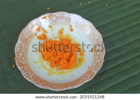 Blur, noise and grain picture of grated turmeric on the little plate.