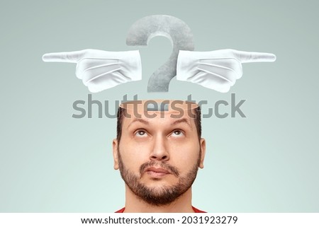In the man's head there is a question mark and index fingers in different directions. The concept of the problem of choice, a difficult decision, to be or not to be, the choice of the path Royalty-Free Stock Photo #2031923279