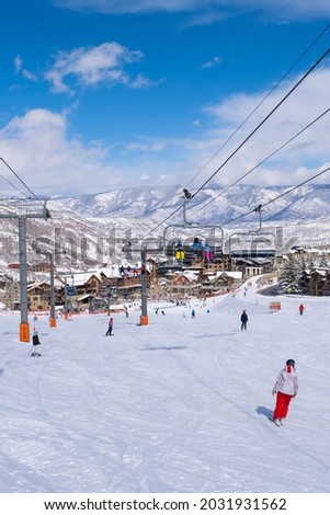 Snow ski resort. Winter landscape. Winter travel, sport and tourism concept. Picture village on mountain. Ski slope and ski lift. Lots people skiing, snowboarding and and enjoing winter vacation.
