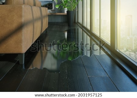 Water leaking and flooded on wood parquet floor. Room floor will damage after the water flooded.  Royalty-Free Stock Photo #2031957125