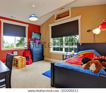 Colorful kids room with beige and red walls. Furnished with single bed and desk