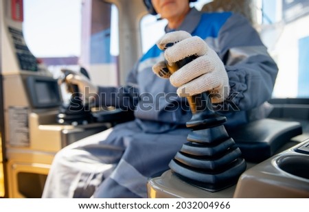 Close-up of builder hands operate crane or excavator at construction site. Royalty-Free Stock Photo #2032004966
