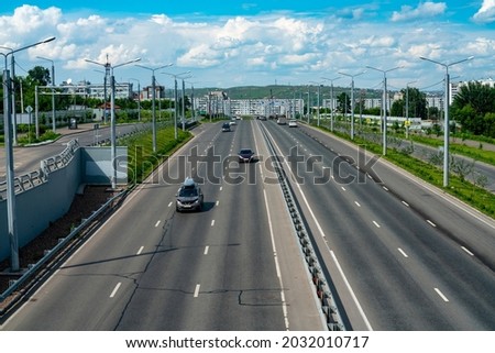 Multi-lane highway with a dividing strip. Busy car traffic on the city highway. Automobile city road on a summer day. Royalty-Free Stock Photo #2032010717