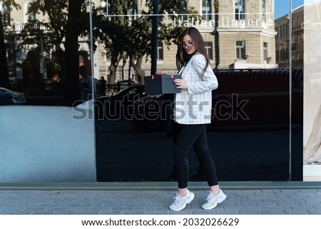 Young girl with black gift box. Happy stylish woman with black box in hands. Woman with gift.