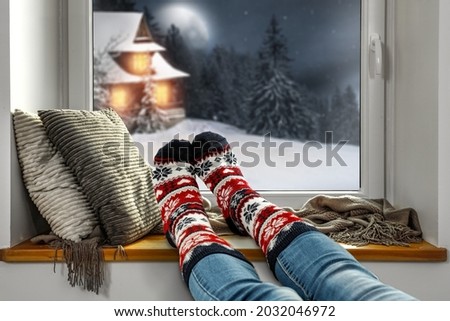 Christmas socka and woman legs with window sill background. Free space for your decoration. 