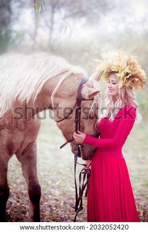 Girl with a wreath of leaves and horse, autumn. Princess