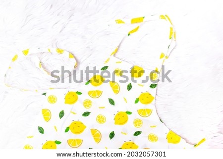 children's set of white clothes with a lemon print. children's apron, headband, socks on a white background.