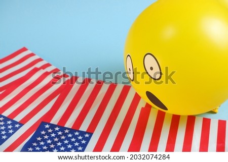Yellow emoji balloons with American flags on a blue background.