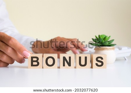 wooden blocks with letters bonus on the office desk, information and communication background, selective focus on office workplace