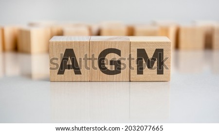AGM word written on wood block. AGM word is made of wooden building blocks lying on the grey table, business concept. AGM short for annual general meeting Royalty-Free Stock Photo #2032077665