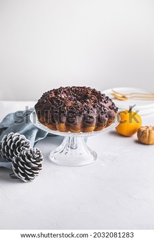Delicious chocolate pumpkin cake on bright modern background with copy space.   Thanksgiving or Christmas-themed postcard.  