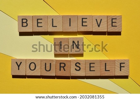 Believe In Yourself, words in wooden alphabet letters isolated on yellow background