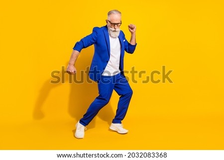 Full size photo of positive grey beard elder man dance wear spectacles blue jacket isolated on yellow background