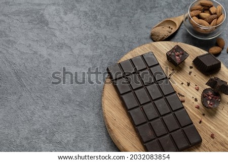 Homemade carob chocolate bar and carob candies on gray background. Healthy food concept.