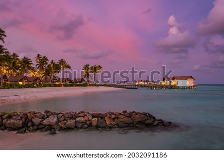 Palm trees on tropical coast at sunset. Crossroads Maldives, hard rock hotel, june 2021. Long exposure picture