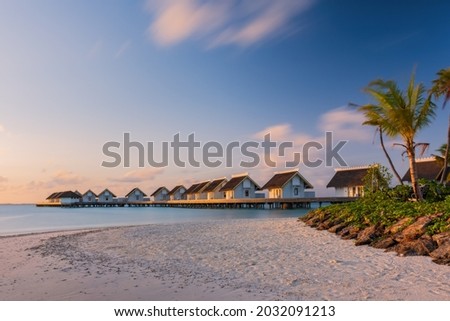 Island in ocean, overwater villas at the time sunrise. Crossroads Maldives,. July 2021. Long exposure picture