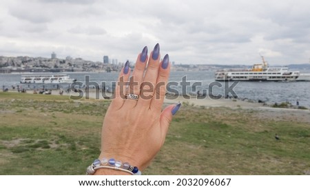Female hands with long nails with light blue lilac nail polish