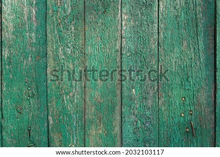 old wooden planks with cracked green paint.